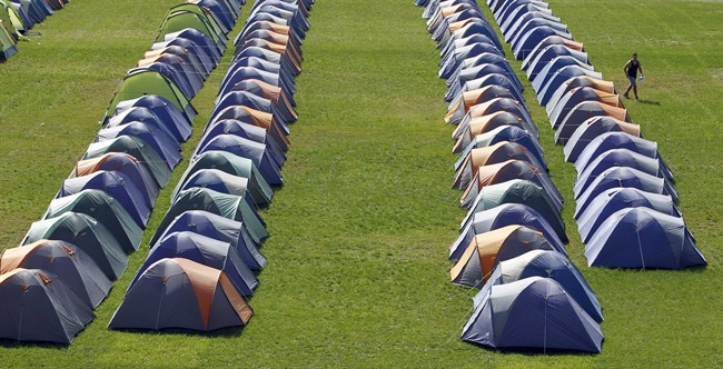 A man walks past tents in the 'Wiesn Loft' riding stadium in Munich, southern Germany, Thursday, Sept. 15, 2011. The tents can be rented as a low cost alternative to expensive hotels during the Oktoberfest, the world's largest beer festival, which runs from Sept. 17 to Oct. 3, 2011. (AP Photo/Matthias Schrader).