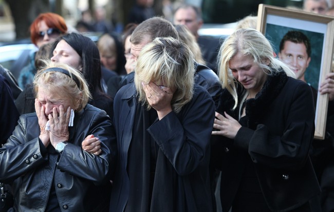 Relatives of Belarusian ice hockey player Ruslan Salei, killed in Wednesday's plane crash near Yaroslavl, mourn during a funeral ceremony in Minsk, Belarus, Saturday, Sept. 10, 2011. The chartered Yak-42 jet crashed Wednesday into the banks of the Volga River moments after takeoff from an airport near Yaroslavl. The crash killed 43 people, including 36 players, coaches and staff of the Lokomotiv Yaroslavl ice hockey team, many of whom were European national team and former NHL players. It was one of the worst aviation disasters ever in sports, shocking Russia and the world of hockey. The team had been heading to Minsk, Belarus to play its opening game of the Kontinental Hockey League season. (AP Photo/Dmitry Brushko).