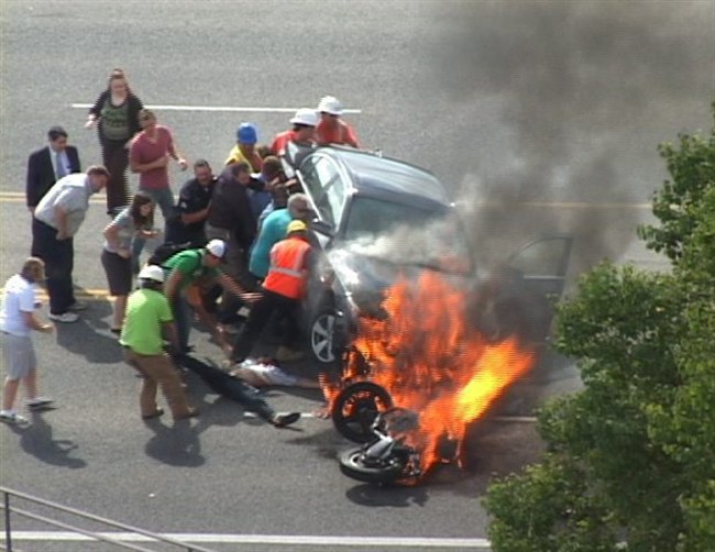 Motorcyclist trapped under burning car says bystanders who lifted