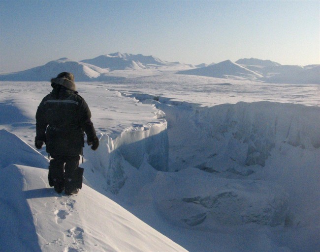 FILE - In this April 1, 2008 file photo, Canadian Ranger Samson Ejanqiaq looks along the length of one of the gaping new cracks in the Ward Hunt Ice Shelf, the largest ice shelf left in the Arctic, during a patrol of the area. This past summer, Ward Hunt Ice Shelf's central area disintegrated into drifting ice masses, leaving two separate ice shelves measuring 87.65 and 28.75 square miles (227 and 74 square kilometers) respectively, reduced from 131.7 square miles (340 square kilometers) the previous year. (AP Photo/The Canadian Press, Bob Weber, File).