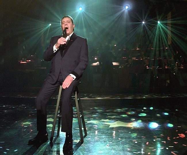 FILE - In this Sept. 6, 1999 file photo, Jerry Lewis sings "You'll Never Walk Alone" as his final song of the 1999 Jerry Lewis Muscular Dystrophy Association Telethon in Los Angeles. The hosts of the 46th annual Muscular Dystrophy Association telethon say Jerry Lewis retired from the yearly fundraiser , the organization's first comments since announcing the beloved icon's departure last month. Co-host Nigel Lythgoe said during his opening comments on the telethon that he didn't realize Lewis was thinking about retirement during the show last year, when the comedian offered Lythgoe his seat during a break in the fundraiser. (AP Photo/Muscular Dystrophy Association, Jay LaPrete, file).