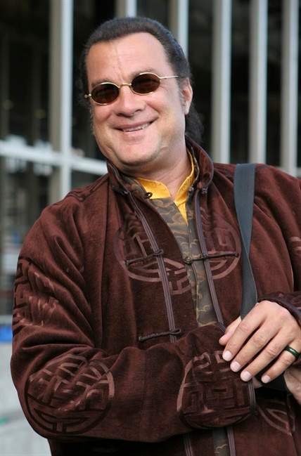 FILE - In this May 18, 2006 file photo actor Steven Seagal smiles on his arrival at Sheremetyevo airport in Moscow. Maricopa County Sheriff Joe Arpaio and actor Steven Seagal deny accusations by Jesus Llovera and his lawyer that a family dog was killed during a raid for Seagal's reality TV show. Llovera has filed a $25,000 claim against the sheriff's office for humiliation, emotional distress and property damage. (AP Photo/Yuri Samoligo, file).