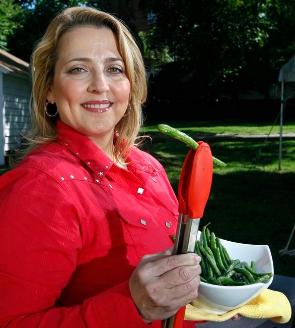 This Friday, Sept. 16, 2011 photo shows chef Elizabeth Karmel as she holds grilled green beans in East Orange, N.J. Karmel is a grilling and Southern foods expert and executive chef at Hill Country Barbecue Market restaurants in New York and Washington, as well as Hill Country Chicken in New York. (AP Photo/Mel Evans).