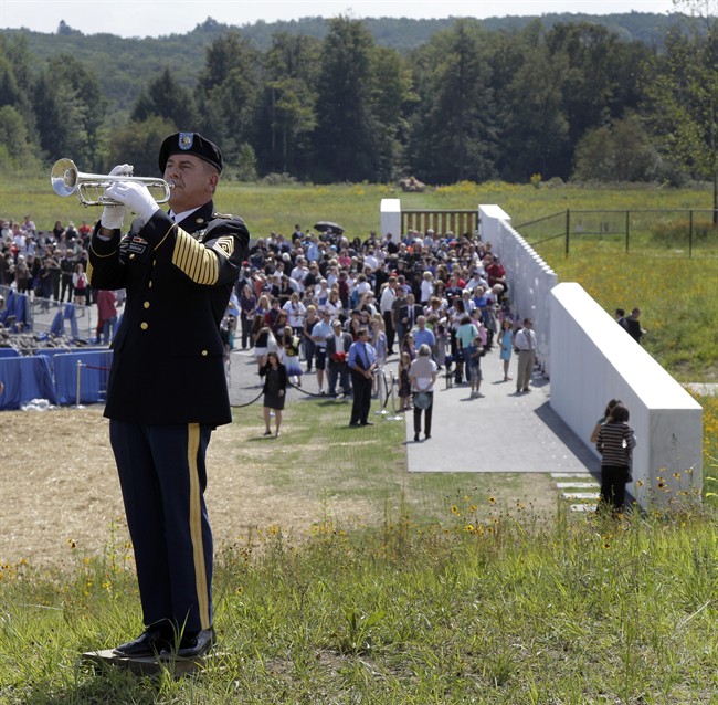 First Sgt. Robert Baranik plays Taps following a ceremony to commemmorate the 10th anniversary of the Sept. 11, 2001 terrorist attacks, on a hill above phase 1 of the permanent Flight 93 National Memorial near the crash site of Flight 93 in Shanksville, Pa. Sunday Sept. 11, 2011. The crash site of United Flight 93 is marked by the large rock in the distance. (AP Photo/Amy Sancetta).