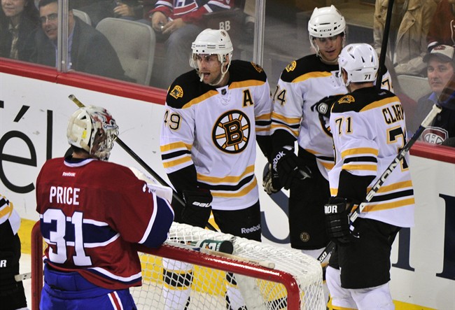 Boston Bruins' Chris Clark, right, celebrates his goal past Montreal Canadiens goalie Carey Price with teammates Rich Peverley, left, and Max Sauve during third period NHL pre-season hockey action Monday, September 26, 2011 in Montreal. The Bruins beat the Canadiens 2-1. THE CANADIAN PRESS/Paul Chiasson.