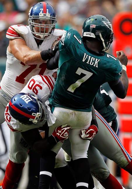 Philadelphia Eagles quarterback Michael Vick (7) is hit by New York Giants defensive ends Jason Pierre-Paul (90) and Dave Tollefson (71) in the second half of an NFL football game, Sunday, Sept. 25, 2011, in Philadelphia. (AP Photo/Alex Brandon).