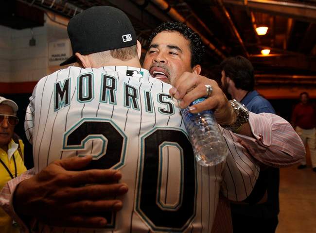 New Florida Marlins manager Ozzie Guillen, right, hugs Florida Marlins' Logan Morrison (20) before a baseball game between the Marlins and Washington Nationals in Miami, Wednesday, Sept. 28, 2011. (AP Photo/Lynne Sladky).