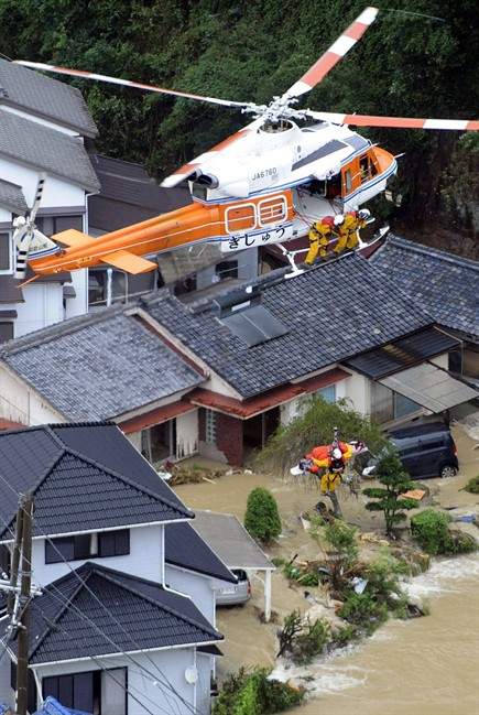Crew members from a prefectural rescue helicopter help a person isolated by a Typhoon Talas-triggered flood in Nachikatsuura, central Japan, Sunday, Sept. 4, 2011. The center of the season's 12th typhoon was moving slowly north across the Sea of Japan, the Japan Meteorological Agency said. (AP Photo/Kyodo News) JAPAN OUT, MANDATORY CREDIT, NO LICENSING IN CHINA, FRANCE, HONG KONG, JAPAN AND SOUTH KOREA.