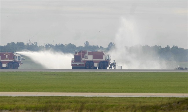 Firefighters extinguish fire from a single engine T-28 Trojan Horsemen Demonstration Flight Team plane that crashed and exploded during a performance at the Thunder Over the Blue Ridge Open House and Air Show, Saturday, Sept. 17, 2011 at the 167th Airlift Wing in Martinsburg, W.Va. (AP Photo/Journal Newspaper, Ron Agnir).