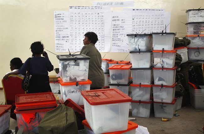 Election volunteers stand by ballot boxes stored at the Civic Center in Lusaka, Zambia, Thursday Sept. 22, 2011. A challenger who has lost three previous presidential polls took a comfortable lead after votes from more than half Zambia's constituencies were tallied Thursday, but unrest was reported among his supporters. The last election was close, and this year's race between President Rupiah Banda and main opposition leader Michael Sata also was expected to be a tight race.(AP Photo/Jerome Delay).