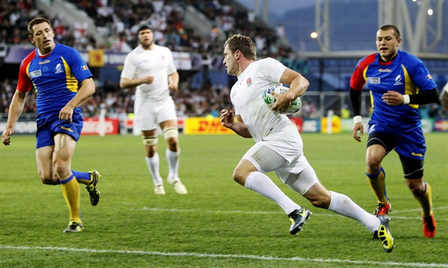 England's Mark Cueto runs in to score a try as Romania's Iulian Dumitras, left, and Ionel Cazan look on during their Rugby World Cup group B pool match at the Otago stadium in Dunedin, New Zealand, Saturday, Sept. 24, 2011. (AP Photo/Alastair Grant).