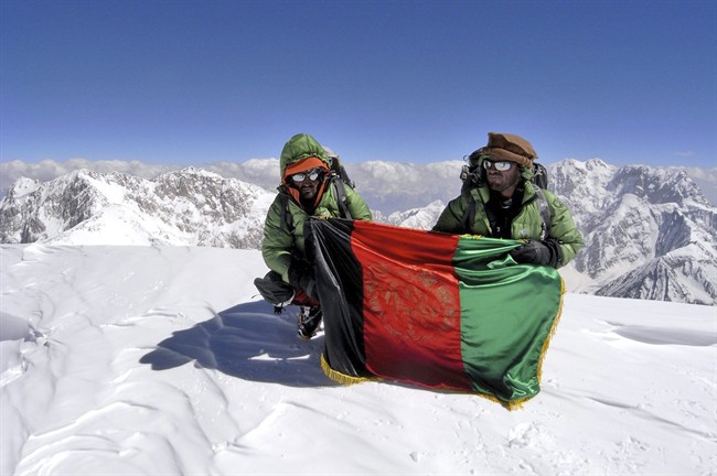 In this July 19, 2009 photo provided by Louis Meunier of Taimani Films, Amruddin Sanjar and Malang Daria hold the Afghan national flag on top of Afghanistan's highest mountain, Noshaq. (AP Photo/Taimani Films).