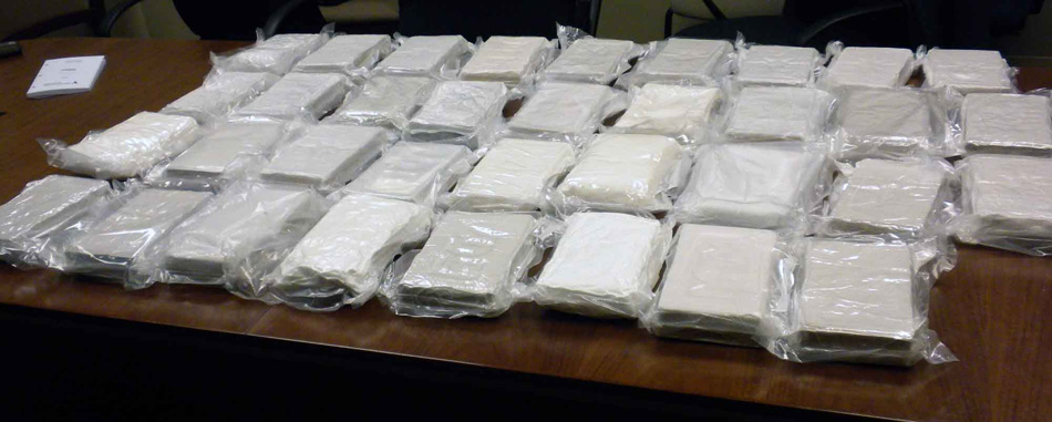 File photo purportedly showing bricks of cocaine. After removing a number of interior panels, investigators say they discovered multiple packages containing 53 kilograms of cocaine and 22 kilograms of methamphetamine.