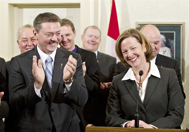 Doug Horner (left), Deputy Premier and President of the Treasury Board of Enterprise, applauds as Alberta Premier Alison Redford announces her new cabinet team after they were sworn- n by Alberta's Lieutenant Governor Donald Ethell in Edmonton, Wednesday, Oct.12, 2011. THE CANADIAN PRESS/Jason Franson.