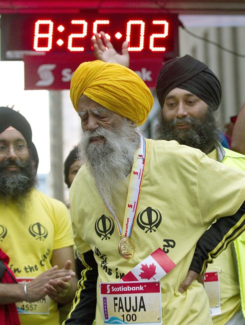 Fauja Singh, aged 100, grimaces and holds his back after crossing the line in the Toronto Waterfront Marathon in Toronto on Sunday October 16, 2011. A 27-year-old participant in a Toronto marathon died just a few hundred metres from the finish line, police and organizers said Sunday. THE CANADIAN PRESS/FRANK GUNN.