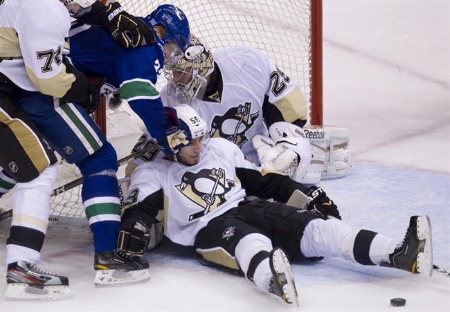 Vancouver Canucks left wing Daniel Sedin (22) tries to get a shot past Pittsburgh Penguins center Evgeni Malkin (71), goalie Marc-Andre Fleury (29) and Paul Thompson (56) during overtime NHL hockey action at Rogers Arena in Vancouver, Thursday, Oct. 6, 2011. The Penguins went on to win the game in a shootout. THE CANADIAN PRESS/Jonathan Hayward.