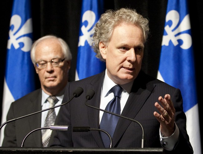 Quebec Premier Jean Charest, right, announces a commission of inquiry in the construction industry Wednesday, October 19, 2011 in Quebec City. Public Security Minister Robert Dutil looks on. THE CANADIAN PRESS/Jacques Boissinot.