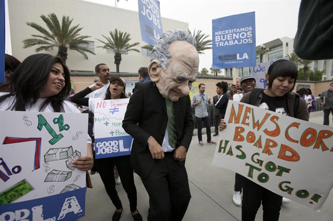 A protestor dressed as News Corp. CEO Rupert Murdock is seen with protestors in front of Fox Studios in Los Angeles on Friday, Oct 21, 2011. A few dozen people showed up to demonstrate outside Fox Studios where News Corp. is holding its annual shareholders meeting. Murdoch is facing shareholders with small stakes in his company for the first time since a phone-hacking scandal broke in July. (AP Photo/Nick Ut).