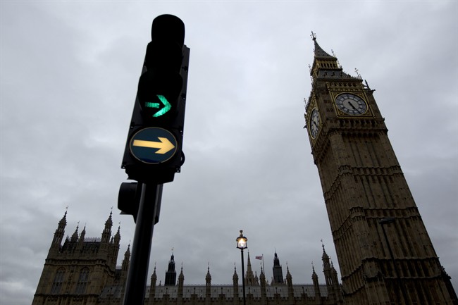 A traffic light illuminates next to the Big Ben clock tower in London, Monday, Oct. 10, 2011. Big Ben has a little bend. Experts say the world-famous neogothic clock tower is listing gently, and documents recently published by Britain's Parliament show that the top of its gilded spire is about one-and-a-half feet (nearly half a meter) out of line. The tower, colloquially known as Big Ben after its massive bell - has been slightly off center since it was erected in the 19th century. Like many old buildings its position has been shifting imperceptibly for years as the ground beneath it subsides. (AP Photo/Matt Dunham).