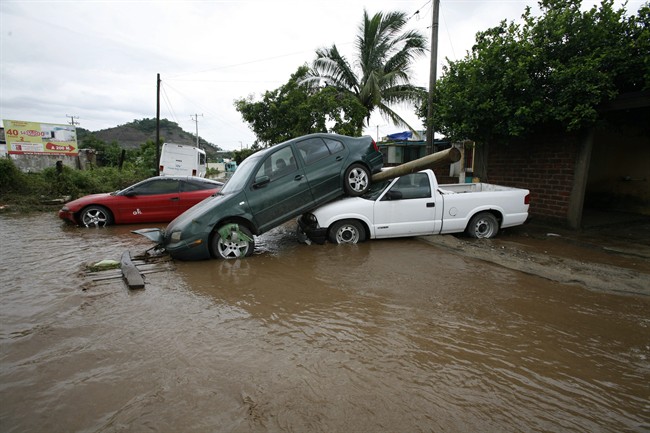 Cars pile up after being dragged by flood waters in Villa de Coral, Mexico, Wednesday Oct. 12, 2011. Hurricane Jova slammed into Mexico's Pacific coast as a Category 2 storm early Wednesday, killing at least two people and injuring some six, while a tropical depression hit farther south and unleashed steady rains that contributed to 13 deaths across the border in Guatemala. (AP Photo/Marco Ugarte).