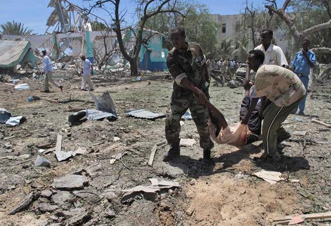 Somalis carry a wounded man at the scene of an explosion in Mogadishu, Somalia, Tuesday, Oct. 4, 2011. A rescue official says at least 55 people were killed after a car laden with explosives blew up in front of the Ministry of Education in the Somali capital of Mogadishu. The al-Qaida-linked militant group al-Shabab immediately claimed responsibility for the attack on a website it uses, after more than a month of relative calm in Mogadishu.(AP Photo/Mohamed Sheikh Nor).