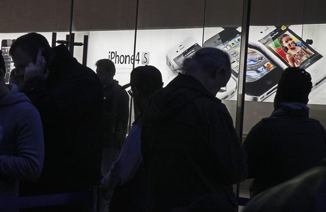 People wait in line buy the new iPhone 4S outside the Apple store, on New York's Upper West Side, Friday, Oct. 14, 2011. A faster iPhone with better software and an improved camera went on sale in seven countries on Friday as hundreds of buyers camped out for hours to be among the first to get one.(AP Photo/Richard Drew).