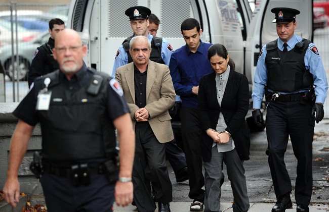Tooba Mohammad Yahya and husband Mohammad Shafia and their son Hamed Mohammed Shafia are escorted by police officers into the Frontenac County Court courthouse in Kingston, Ontario on Thursday, October 20, 2011.