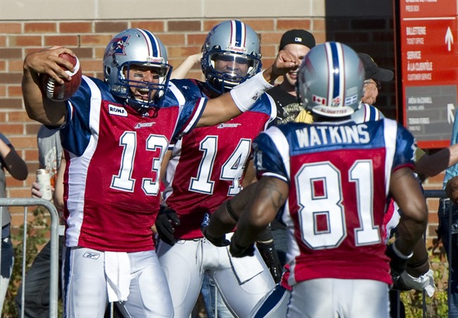 Montreal Alouettes quarterback Anthony Calvillo celebrates after scoring a touchdown against the Toronto Argonauts with teammates Brandon London, rear, and Kerry Watkins, right, during third quarter CFL football action Monday, October 10, 2011 in Montreal. THE CANADIAN PRESS/Paul Chiasson.