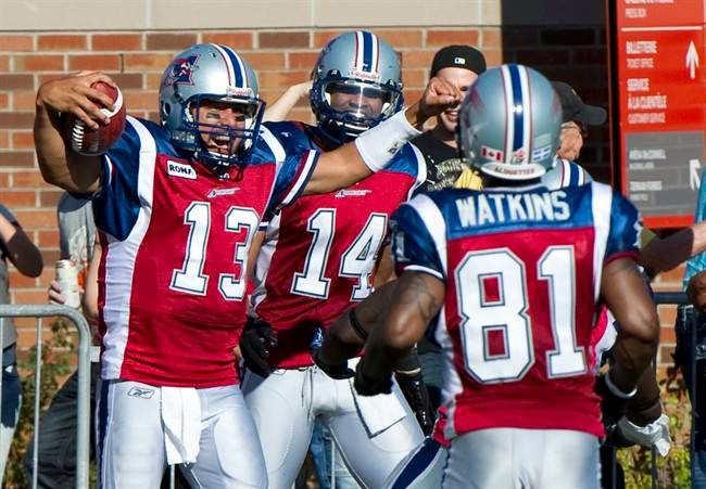 Montreal Alouettes quarterback Anthony Calvillo celebrates after scoring a touchdown against the Toronto Argonauts with teammates Brandon London, rear, and Kerry Watkins, right, during third quarter CFL football action Monday, October 10, 2011 in Montreal. THE CANADIAN PRESS/Paul Chiasson.