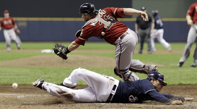 Arizona Diamondbacks catcher Miguel Montero can't catch the throw as Milwaukee Brewers' Jerry Hairston Jr. scores from third on a squeeze bunt by Jonathan Lucroy during the sixth inning of Game 2 of baseball's National League division series Sunday, Oct. 2, 2011, in Milwaukee. (AP Photo/David J. Phillip).