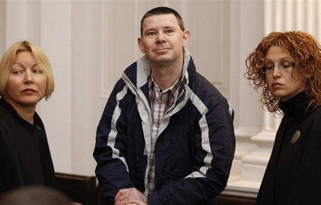 Michael Campbell, a 39-year-old with alleged links to the Real Irish Republican Army, center, is seen before a court session in Vilnius, Lithuania , Friday, Oct 21, 2011. A judge found Campbell guilty Friday of trying to buy weapons and explosives during a six-year sting orchestrated by Britain's domestic spy agency MI5, in a case that drew attention to a hardcore Irish Republican Army splinter group's plans to spread terror to London. (AP Photo/Mindaugas Kulbis).