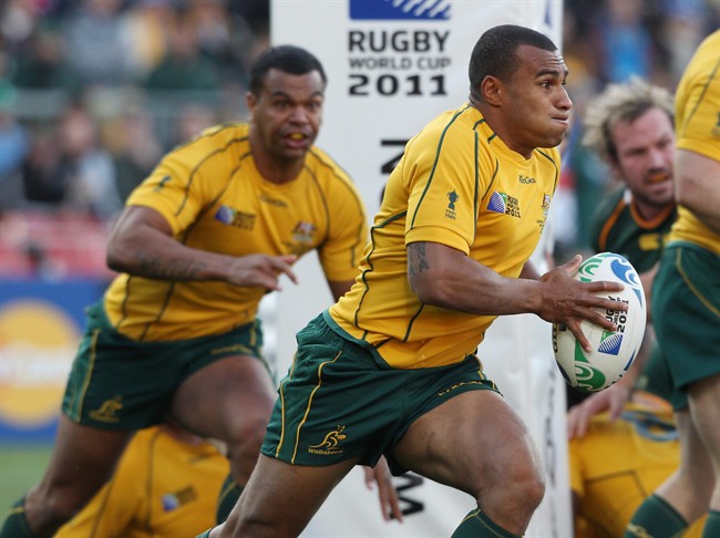 Australia's Will Genia runs down the field as teammate Kurtley Beale, left, looks on during their Rugby World Cup quarterfinal against South Africa in Wellington, New Zealand, Sunday, Oct. 9, 2011.(AP Photo/Rob Griffith).