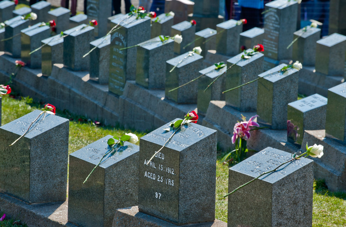 Flowers are placed on tombstones during a public interfaith memorial service at the Fairview Lawn Cemetery in Halifax on April 15, 2012 in remembrance of the lives lost in the Titanic tragedy and of the 121 Titanic victims buried at the cemetery.