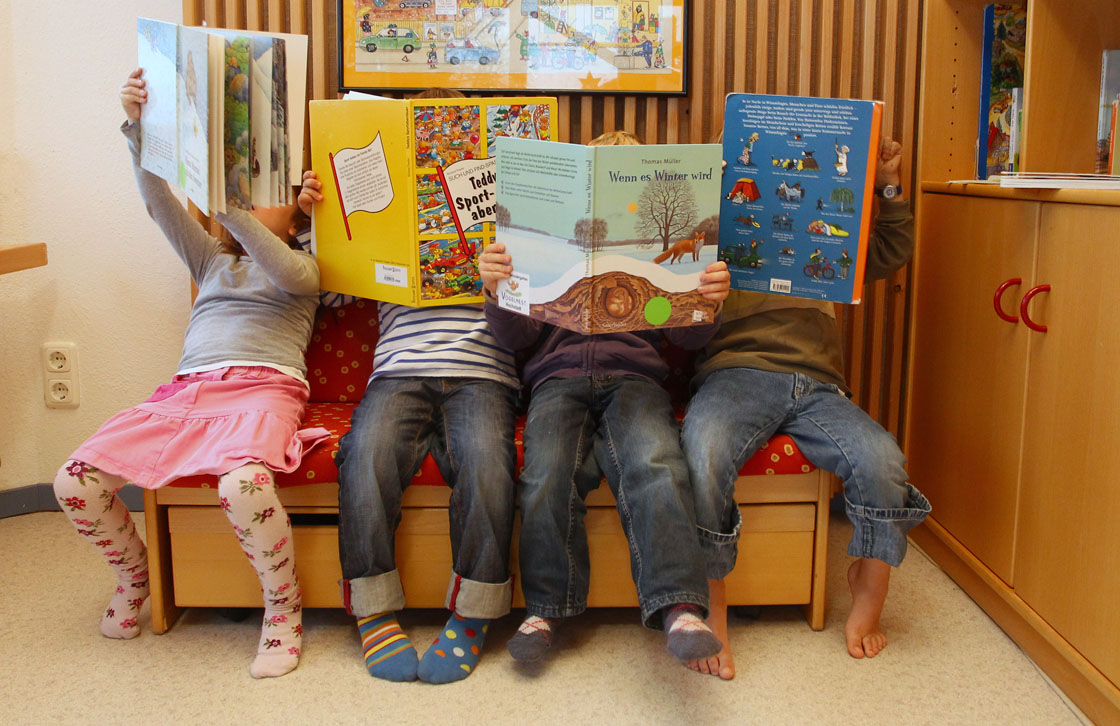 Children look at books at a day care center for children aged 12 months to six years on December 22, 2011 in Munich, Germany.