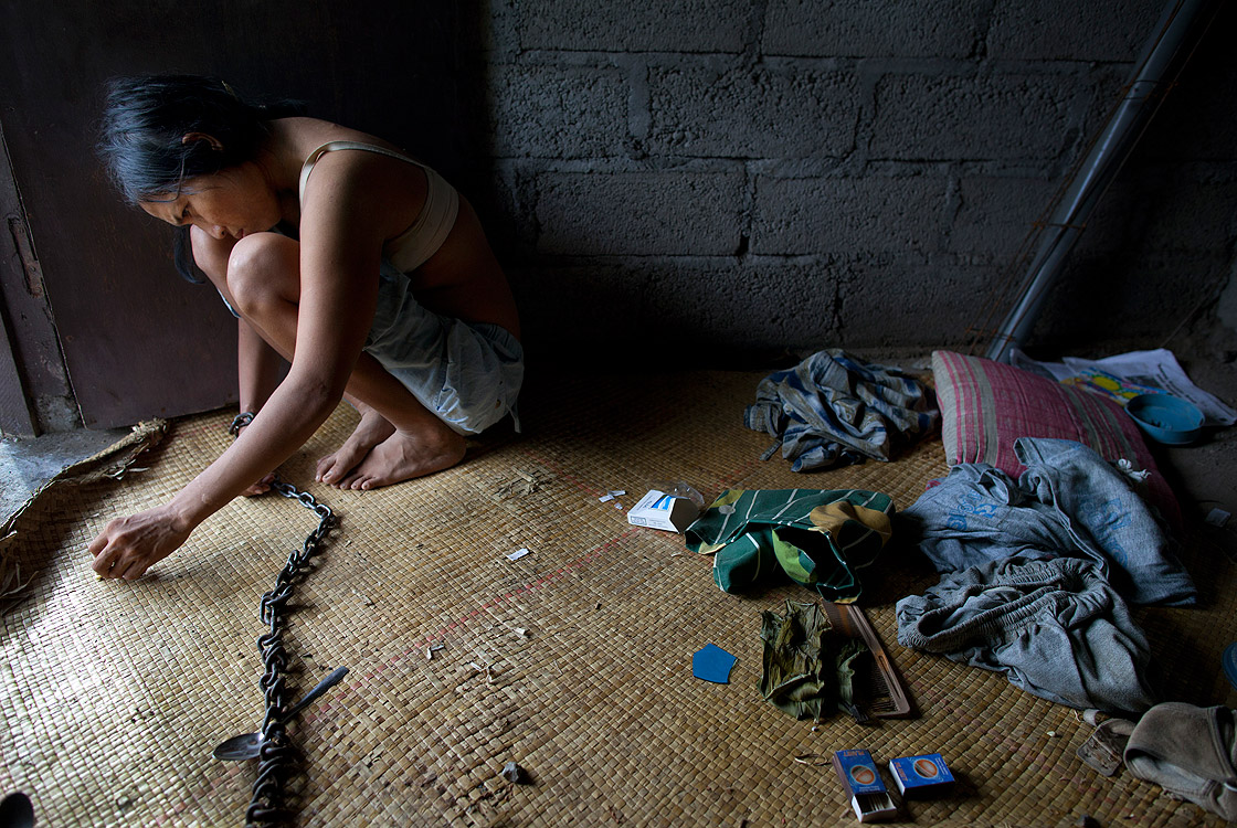 Komang, 27, who is diagnosed with Schizophrenia, sits in her room where she is chained May 4, 2012 in Buleleng, Bali, Indonesia. 