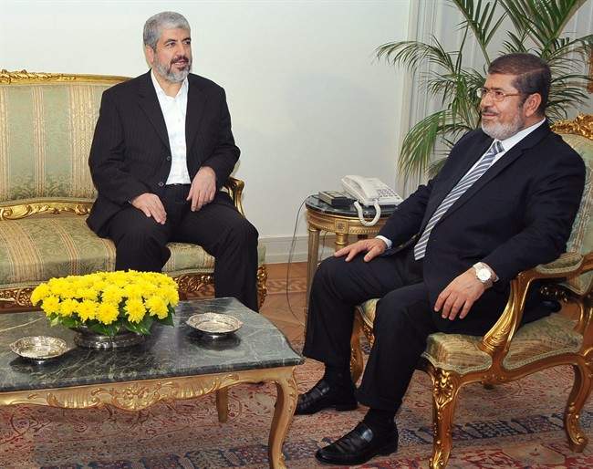 In this image provided by the Egyptian President, Hamas leader Khaled Mashaal, left, meets with Egyptian President Mohammed Morsi at the Presidential Palace in Cairo, Sunday, Nov. 18, 2012. About 500 Egyptian activists have crossed into Gaza to deliver medical supplies and show support for Palestinians facing an Israeli offensive. Morsi, comes from the Muslim Brotherhood, the parent group of Hamas and has met with Hamas leaders in Cairo. (AP Photo/Egyptian Presidency).