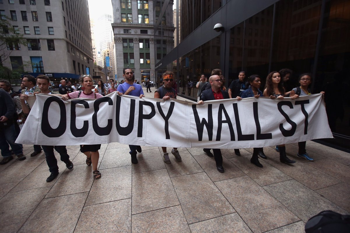 Protesters march near the New York Stock Exchange during a demonstration marking the one-year anniversary of the Occupy Wall Street movement .
