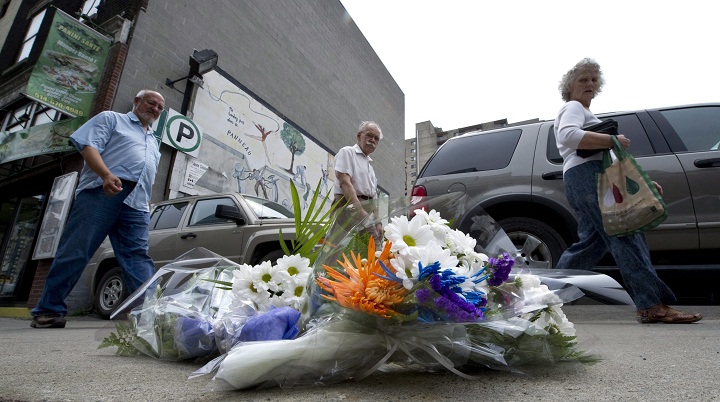 Flowers mark the site where hospital worker Patrick Limoges, 36, an innocent bystander, was shot by Montreal police after officers opened fire on Tuesday and killed a knife-wielding homeless man, in Montreal,  Wednesday, June 8, 2011.