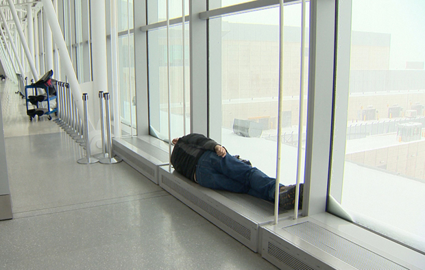 A person takes a rest while waiting through delays and cancellations at Pearson International Airport in Toronto. February 8, 2013.