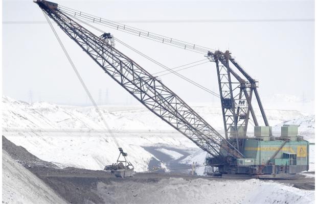 The giant drag line turns the snow black as it exposes coal on March 17, 2013, at Transalta’s Highvale mine, which feeds the Sundance Power Station.