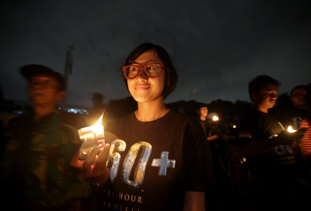 An Indonesian girl holds a candle during the "Earth Hour" in Jakarta, Indonesia, Saturday, March 23, 2013. Hundreds of people gathered in Jakarta Friday to observe the global event that encourages people to turn off their lights for 60 minutes. 