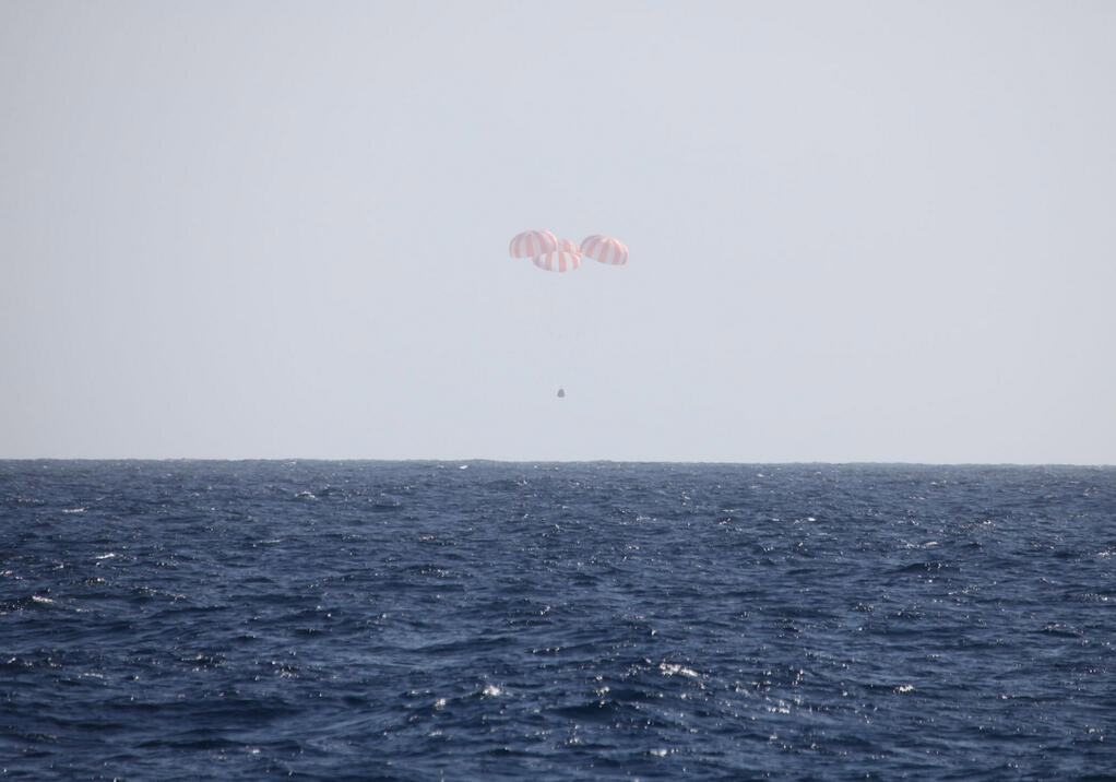 In this image provided by SpaceX, the Dragon capsule uses parachutes to descend to the Pacific Ocean off the coast of Mexico's Baja Peninsula after leaving the International Space Station. 