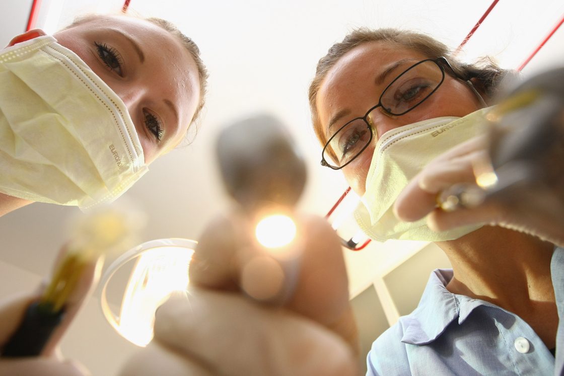 A dentist and her assistant prepare to clean a patient's teeth in this photo illustration at a dentist's office on October 12, 2009 in Berlin, Germany.