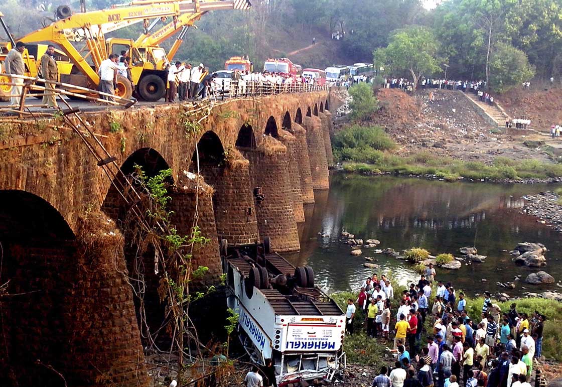 Rescuers and others gather at the site of a bus accident in Ratnagiri district, in the western Indian state of Maharashtra, Tuesday, March 19, 2013. The bus packed with passengers crashed through a guard rail and fell off a bridge in western India early Tuesday, killing at least 37 people and injuring another 15, police said.  

