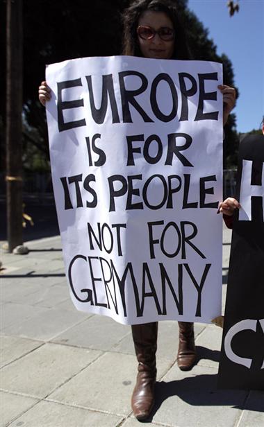 A woman holds up a poster during a protest outside the parliament building in Nicosia;on March 18;2013.
