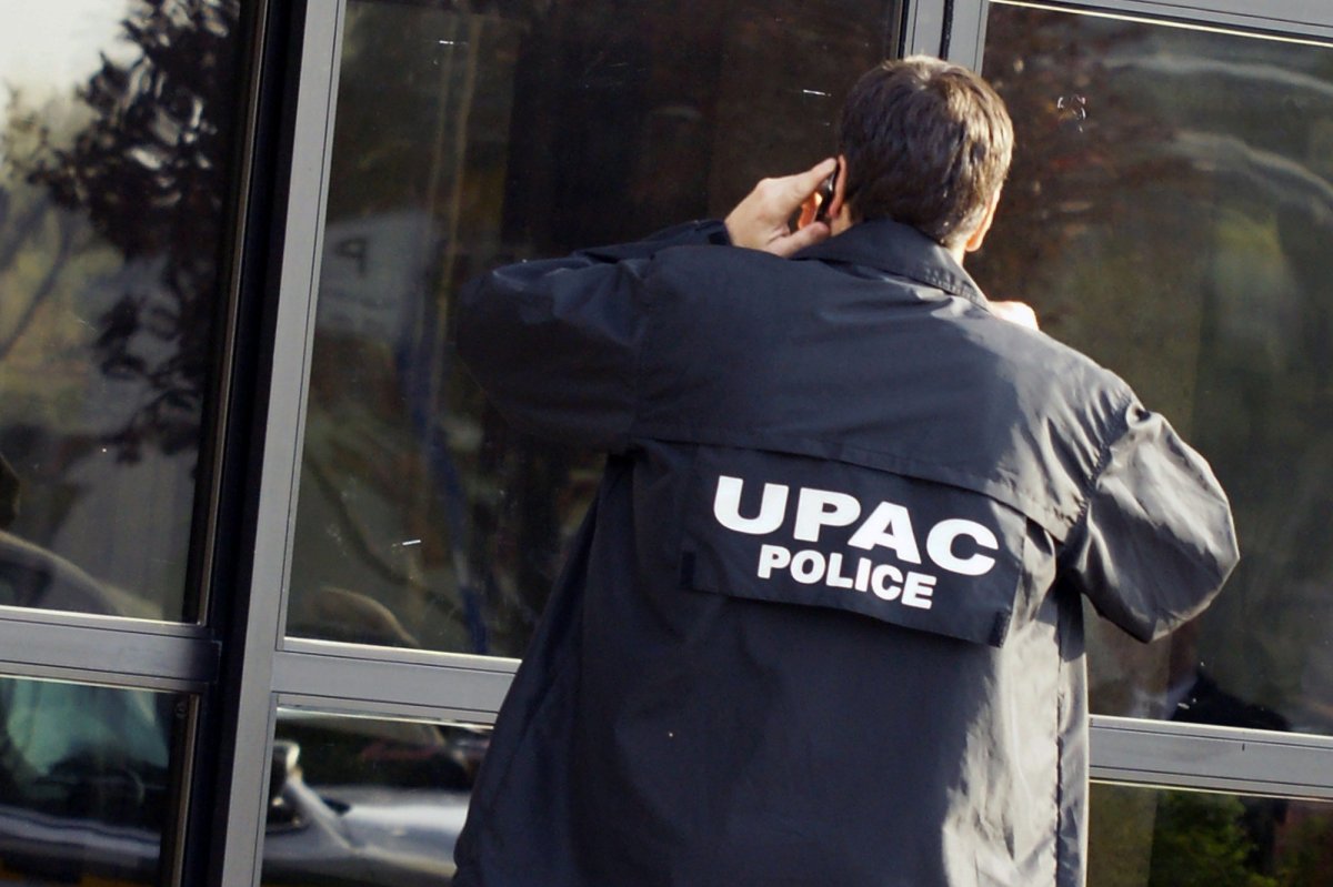 Police officer on the UPAC squad entering Laval city hall.