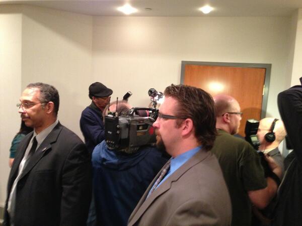 Security guards stand by as media interview federal Aboriginal Affairs Minister Bernard Valcourt.
