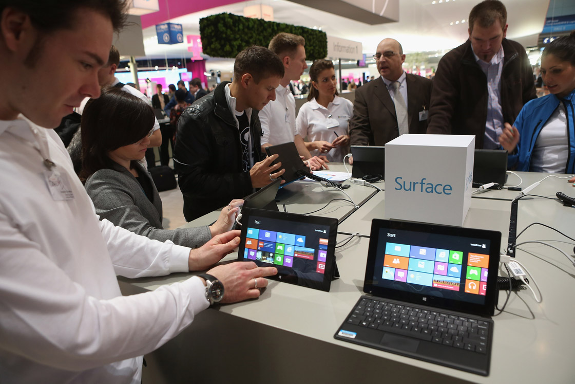 Visitors try out Windows 8 Surface tablet computers at the Microsoft stand at the 2013 CeBIT technology trade fair on March 5, 2013 in Hanover, Germany. 