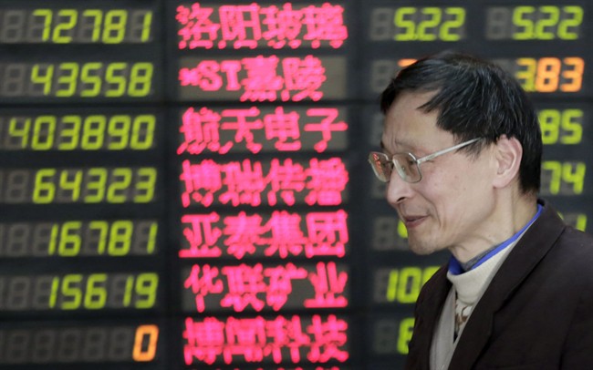 An investor looks at the stock price monitor at a private securities company on Thursday in Shanghai, China. Renewed jitters about the debt crisis in Europe sent Asian stock markets lower.