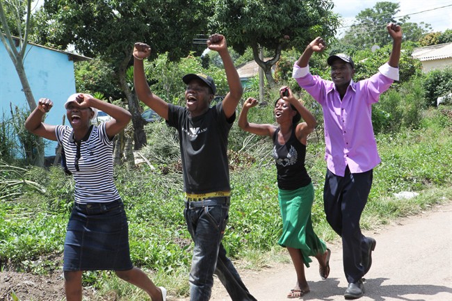 Supporters of Zimbabwean President Robert Mugabe greet his arrival to cast his vote during the country's referendum in the capital Harare, Saturday, March, 16, 2013. The country is holding a referendum on a new constitution which will pave way for the adoption of the draft constitution as the country prepares to hold elections later in the year.(AP Photo/Tsvangirayi Mukwazhi).